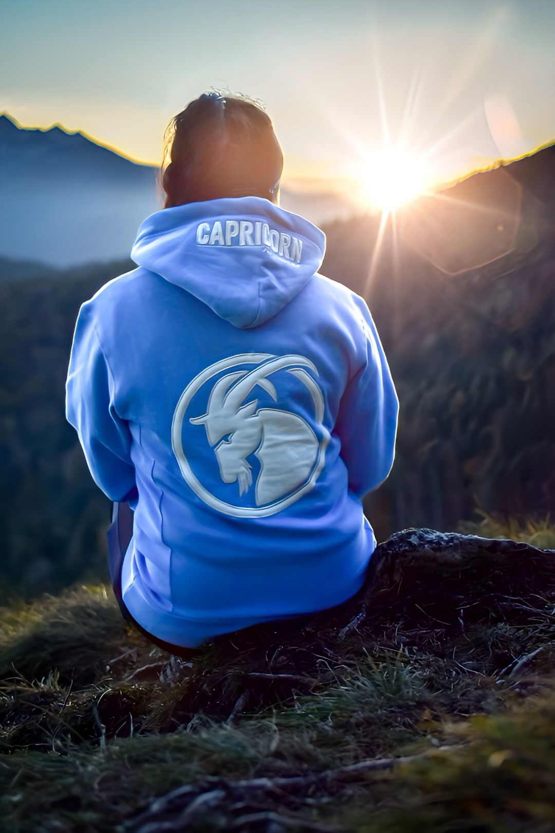 Hoodie in hellblau mit weißen aufgenähtem Steinbock Kopf auf dem Rücken. Getragen von weiblichem Model