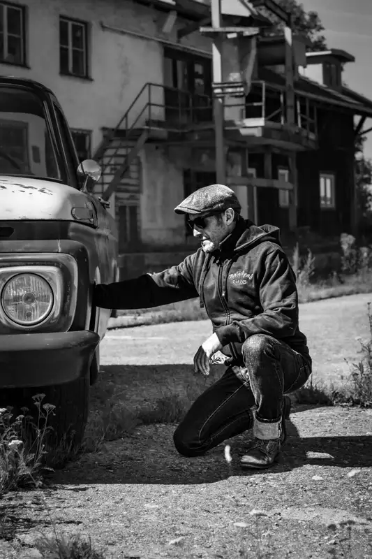 Mann kniend neben Ford Pickup