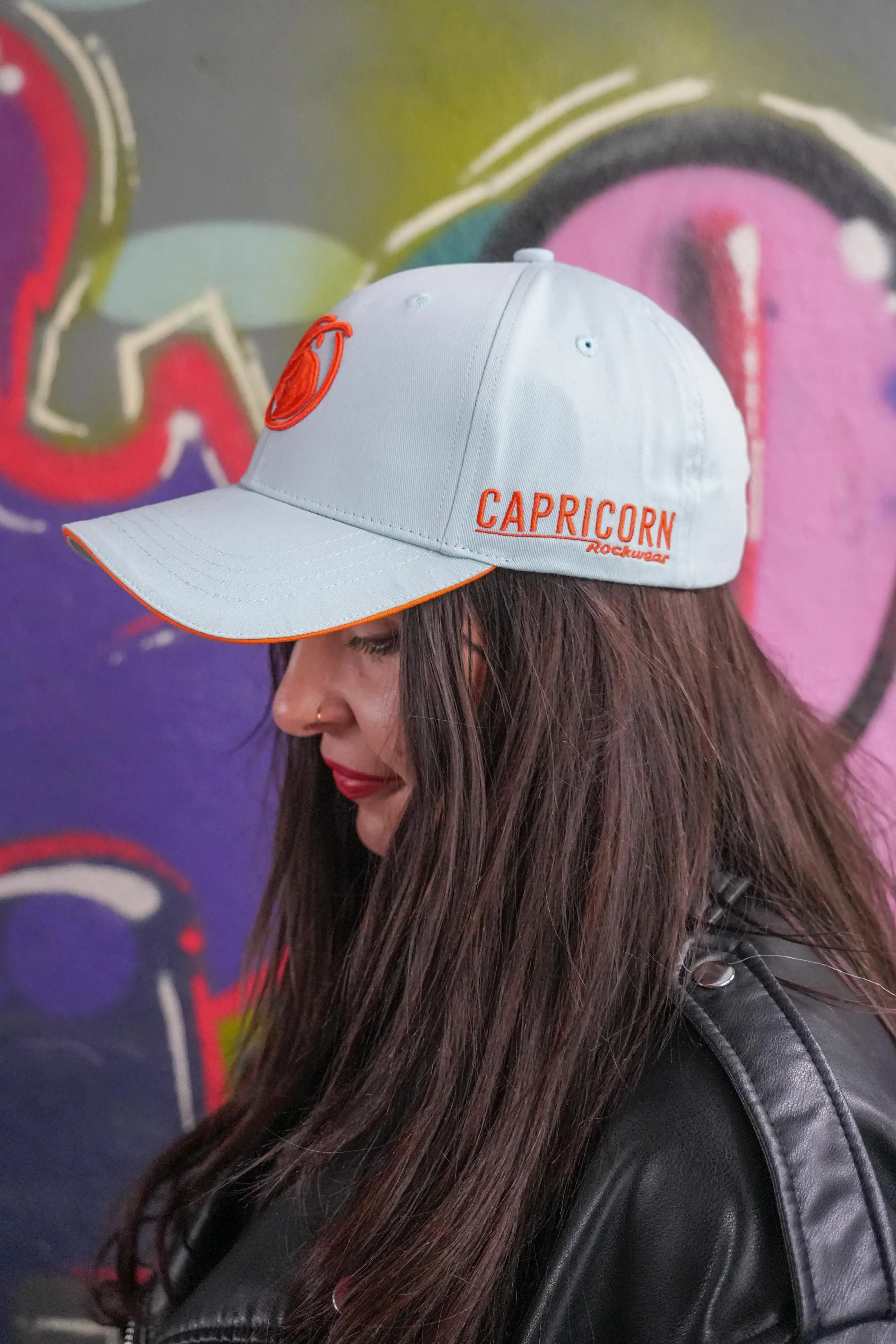 hellblaue Baseball Cap mit orangefarbenen Schriftzug an der Seite von Frau getragen