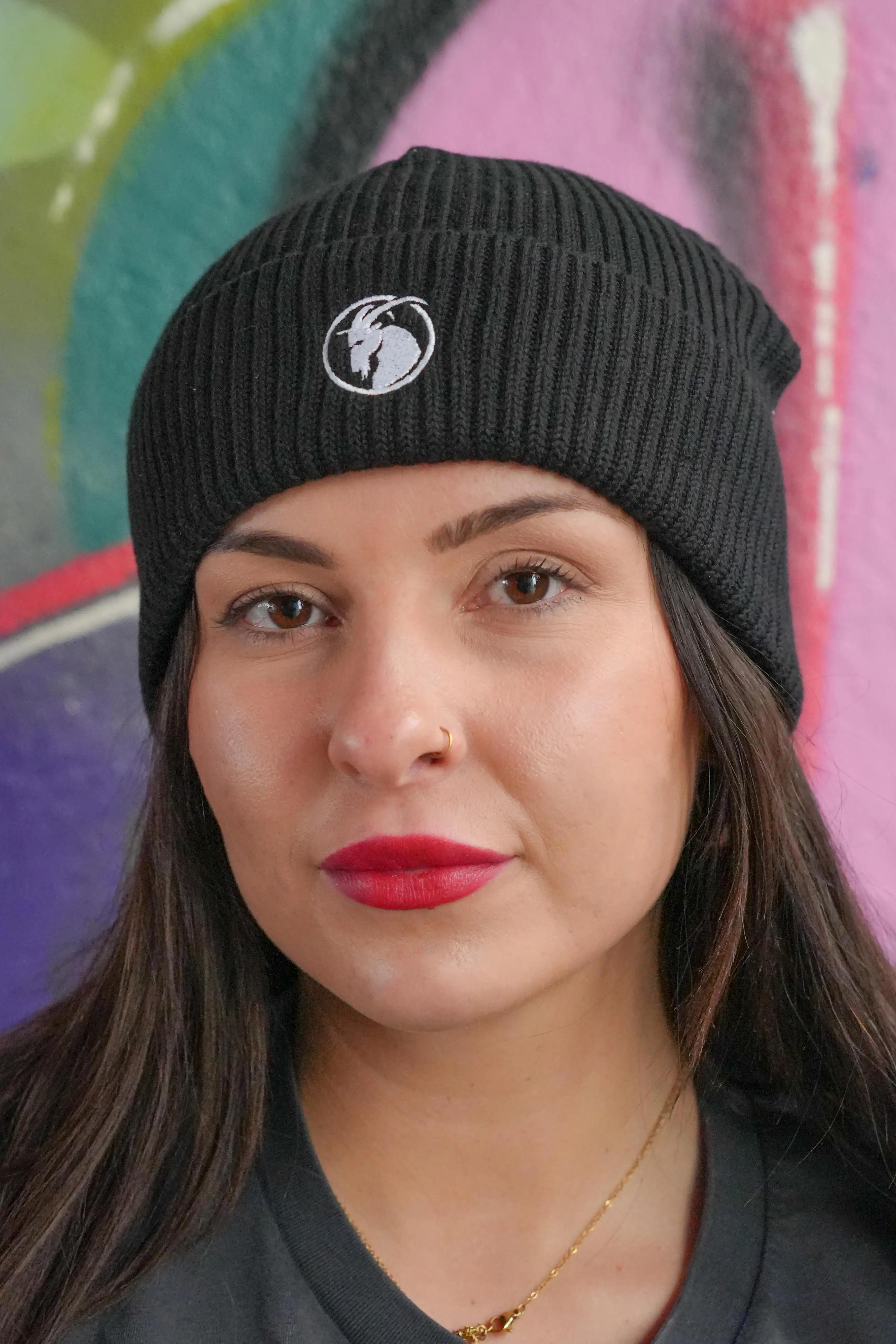 Beanie schwarz mit weißem Steinbock Stick getragen von weiblichem Model