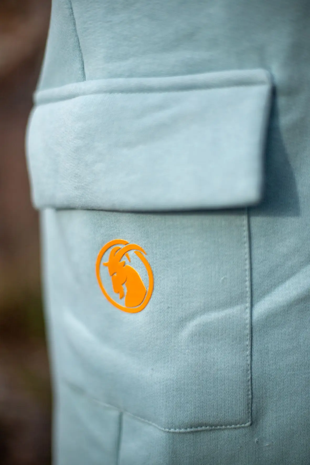 Seitentaschehellblaue Hose mit orangefarbenem Steinbock Rubberprint