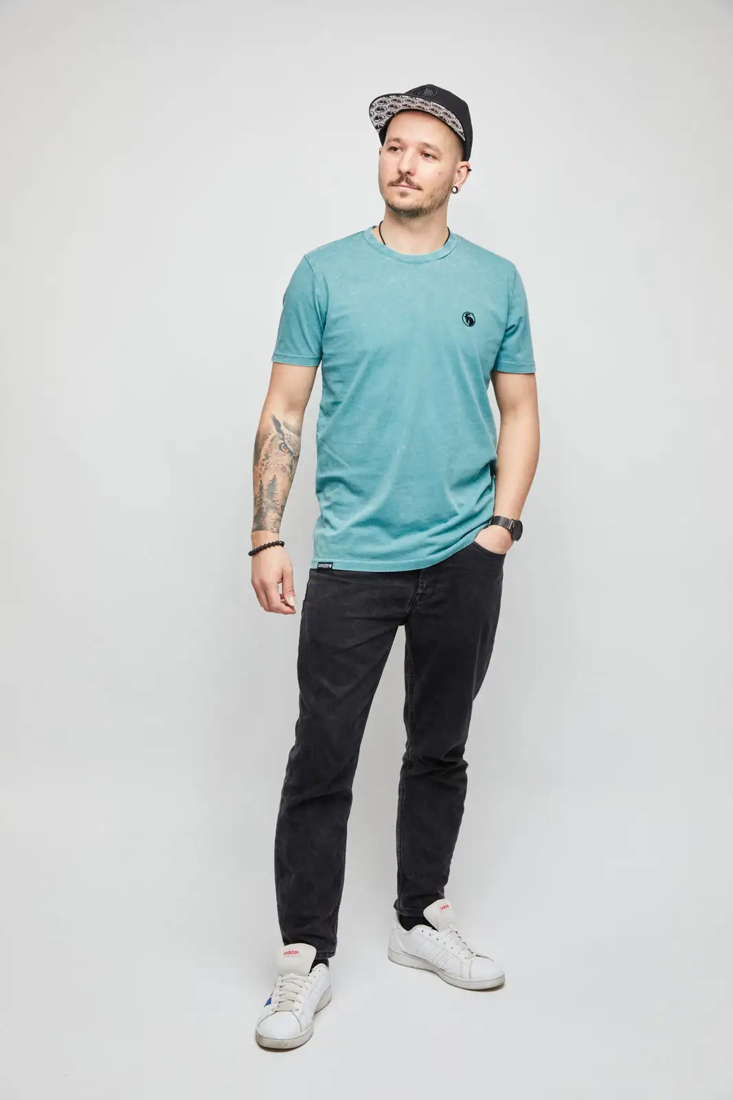 Männliches Model mit grünem Z-Shirt und schwarzer Snapback Cap