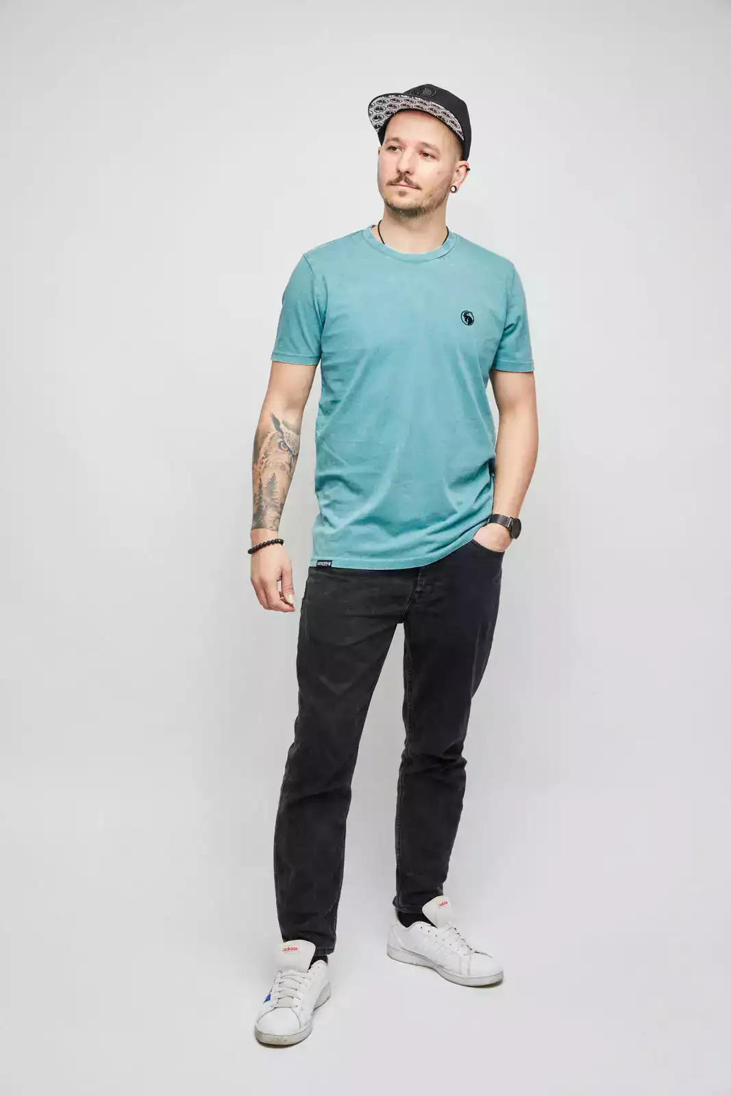 Mann mit grünem T-Shirt und schwarzer Snapback