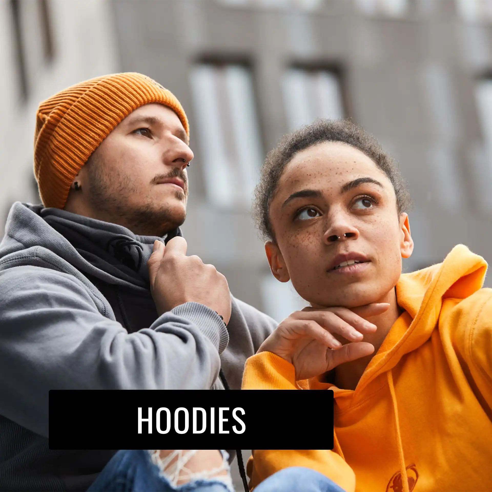 Mann mit grauer Kapuzenjacke, Frau mit orangefarbenem Hoodie sitzend