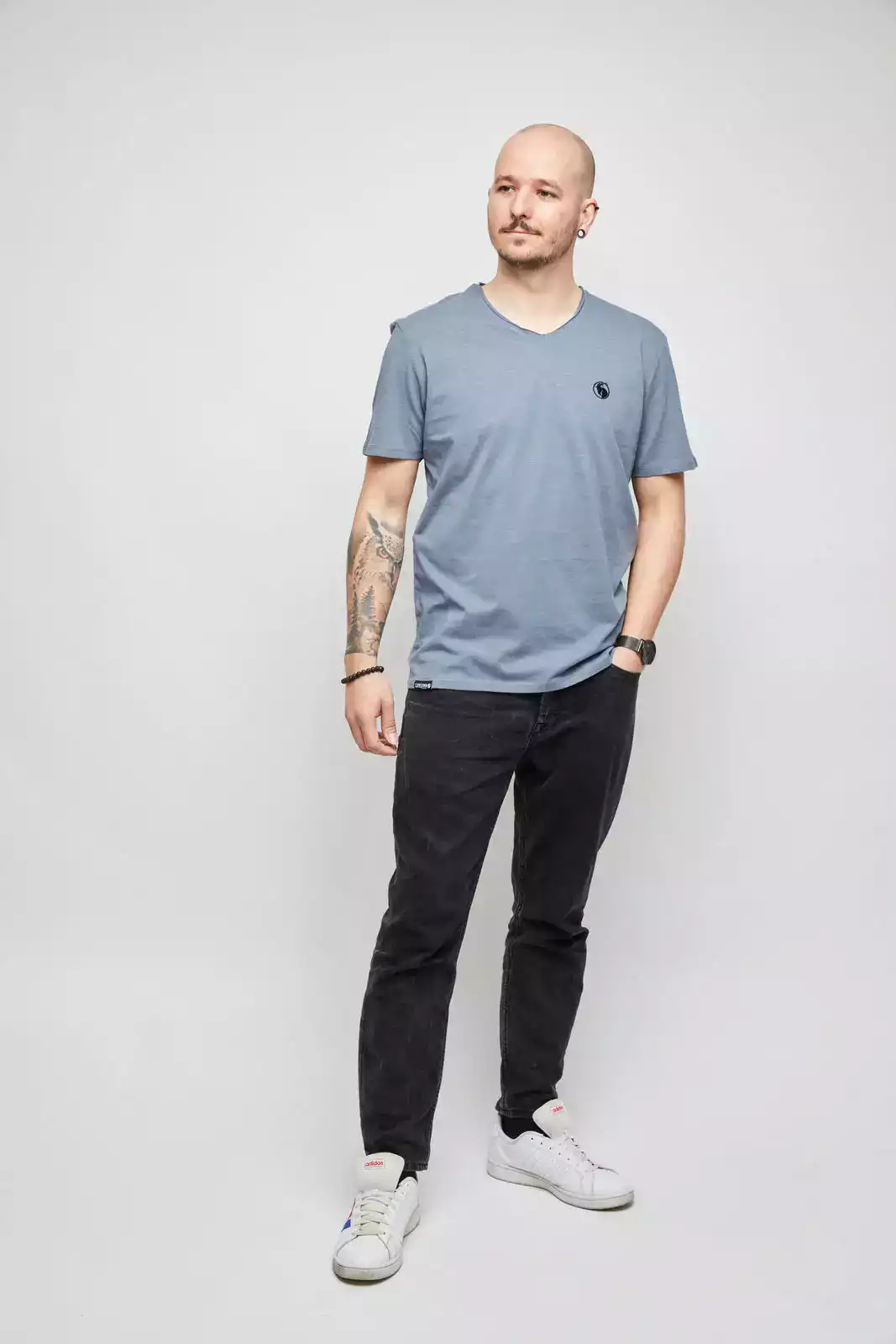 Mann mit grauem T-Shirt. Studioaufnahme