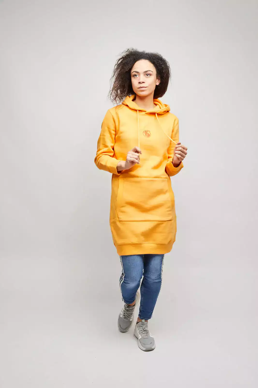 Model mit orangefarbenem Swetkleid. Studioaufnahme